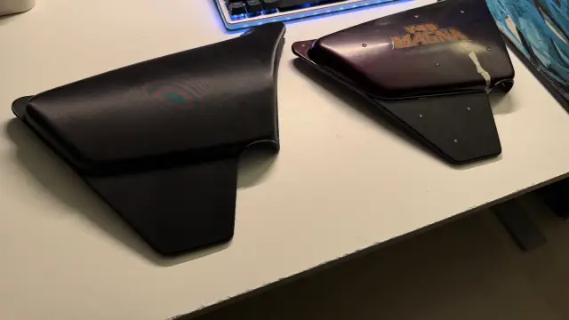 Matte black printed battery door on a desk beside the original purple Honda V45 Magna side cover