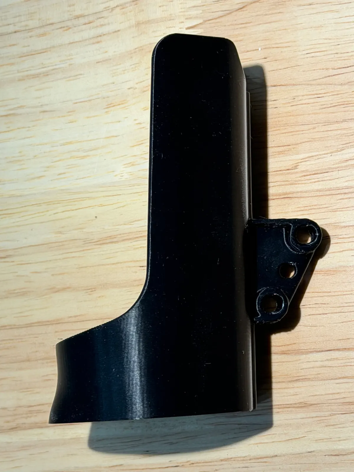 Side view of the black holder showing the mounting tab with three screw holes